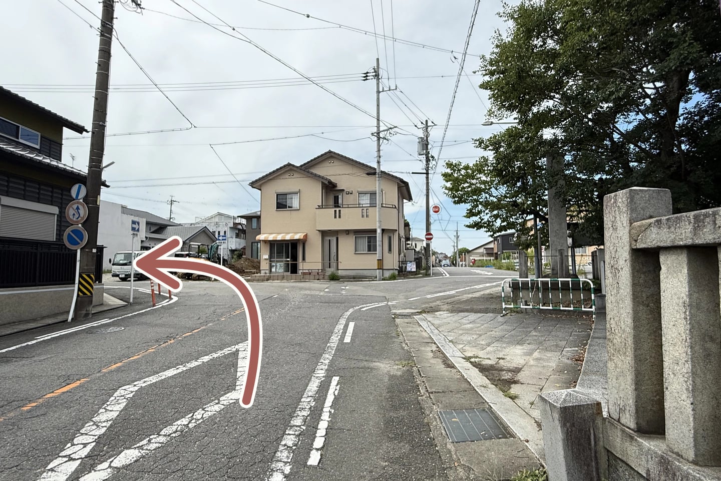 右側の伊文神社に沿って斜め左へ進む方向を矢印で示した写真