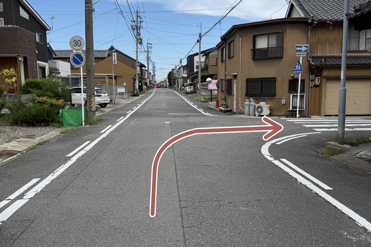 信号から進んだ先の最初の曲がり角を右折する方向を示した写真